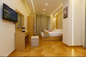 um quarto com uma cama e uma TV de tela plana em AKEN Pyramids View em Cairo