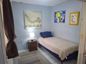 une chambre avec deux lits et une lampe sur une table dans l'établissement Tropical Palm Retreat, à Willemstad