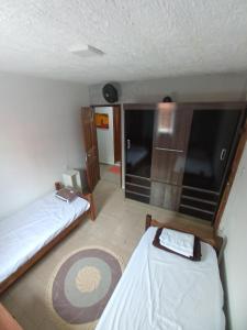 a small room with two beds and a kitchen at HOSTEL da FLORESTA - centro BH in Belo Horizonte