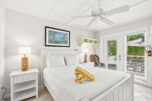 a bedroom with a white bed and a ceiling fan at Anna Cabana Bungalow #3 in Holmes Beach +49 photos