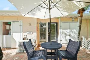 a table and chairs with an umbrella on a patio at Anna Cabana Bungalow #3 in Holmes Beach