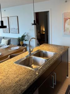 Una cocina con un fregadero de acero inoxidable en una encimera. en The Altitude with Mountain & City Views, Pool & Hot Tub, en Vancouver