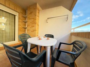 a white table and chairs in a room at ACV - Costa Azahar I-2ª Linea Planta 2 Norte in Oropesa del Mar