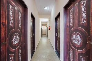 a corridor with wooden doors in a hallway at Hotel O Starlight Stay Jaipur International Airport in Jaipur