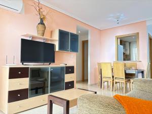 a living room with a tv and a couch and a table at ACV - Costa Azahar I-2ª Linea Planta 2 Norte in Oropesa del Mar