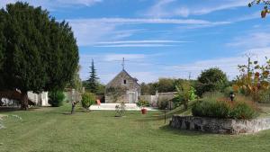 a yard with a stone building and a house at La Récré in Restigné