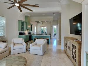 a living room with a ceiling fan and a kitchen at Blue Mountain Bella in Blue Mountain Beach
