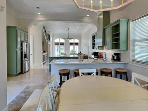a kitchen with green cabinets and a table with stools at Blue Mountain Bella in Blue Mountain Beach