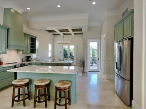 a kitchen with green cabinets and a large island with bar stools at Blue Mountain Bella in Blue Mountain Beach +33 photos