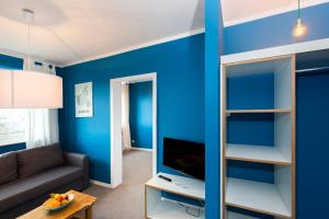 a living room with a blue accent wall at Boardinghouse St.Pauli in Hamburg
