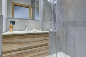 ein Badezimmer mit Dusche, Waschbecken und Spiegel in der Unterkunft Escapade luxueuse avec jacuzzi et sauna au cœur du domaine des Portes du Soleil in Montriond + 19 Fotos