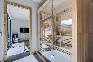 eine Glastür, die zu einem Zimmer mit Balkon führt in der Unterkunft Escapade luxueuse avec jacuzzi et sauna au cœur du domaine des Portes du Soleil in Montriond