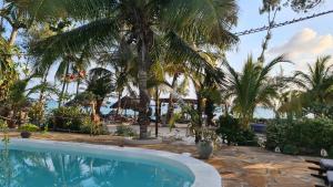 una piscina con palme in un resort di Solaya Residence - Boutique Beach-House in Kizimkazi with Garden & Parking 