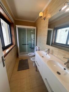 a bathroom with two sinks and a toilet and a mirror at Maia Oporto Suites in Maia
