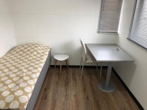 a room with a bed and a table and a chair at Drive inn Room&Shower in Rīga