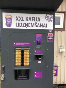 a vending machine with a cup of coffee on it at Drive inn Room&Shower in Rīga