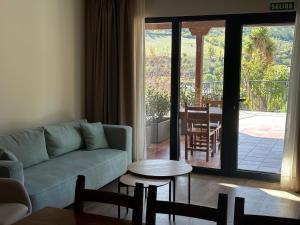 una sala de estar con un sofá y una mesa en El Balcón de Potes, en Potes