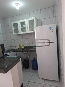 a kitchen with a white refrigerator and white cabinets at my sweet place 19 in São Luís