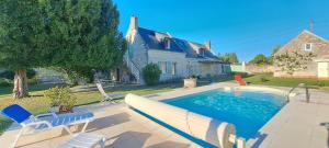 a swimming pool with a slide in front of a house at La Récré in Restigné