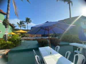 un tavolo con ombrellone blu su un patio di Golden Dolphin Taperapuan Apt 529 a Porto Seguro