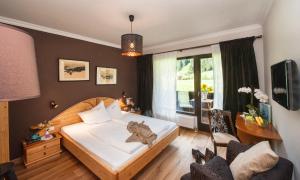 sypialnia z łóżkiem i dużym oknem w obiekcie Hotel LÄRCHENHOF w mieście Kleinarl +37 zdjęć