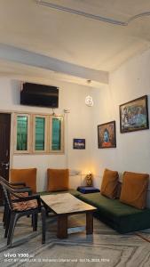 Una sala de estar con un sofá verde y una mesa. en The GreenView HomeStay, en Rishīkesh