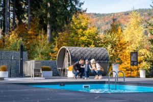 un groupe de personnes assis à côté d'une piscine dans l'établissement Czarny Kamień Resort & SPA, à Szklarska Poręba