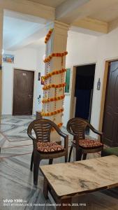 Una habitación con dos sillas y una mesa y una columna. en The GreenView HomeStay, en Rishīkesh
