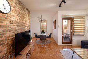 a living room with a large television and a brick wall at Sunset in Kriva Palanka +24 photos