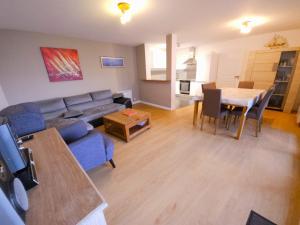 ein Wohnzimmer mit einem blauen Sofa und einem Tisch in der Unterkunft Résidence Brise de Mer - 1 in Port Nayalo