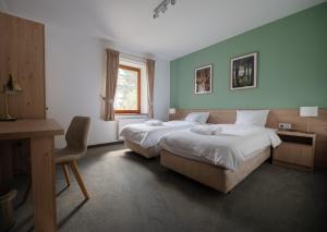 a hotel room with two beds and a desk and a desk at Szumi Las Events & Apartments in Regimin +43 photos