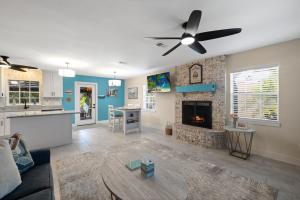 a living room with a ceiling fan and a fireplace at Cedar Key Seaside Escape in Cedar Key