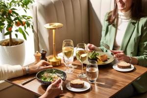 un gruppo di persone seduti intorno a un tavolo con cibo e vino di Sofitel Paris Arc De Triomphe a Parigi