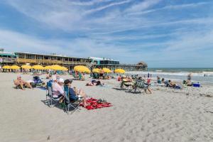 a group of people sitting on a beach with yellow umbrellas at Tropical Beach Studio Getaway B in Cocoa Beach +17 photos