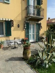 a building with a patio with a table and a balcony at La casa di nonna Rosmi in Saluzzo