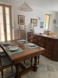 a dining room with a wooden table and a kitchen at La casa di nonna Rosmi in Saluzzo