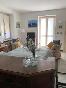 a living room with a table in front of a bed at La casa di nonna Rosmi in Saluzzo