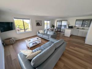 a living room with a couch and a table at Sails in the heart town walk to beach and coffee in Kingscote