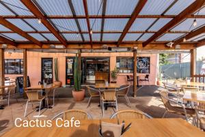 a restaurant with wooden ceilings and tables and chairs at Sails in the heart town walk to beach and coffee in Kingscote