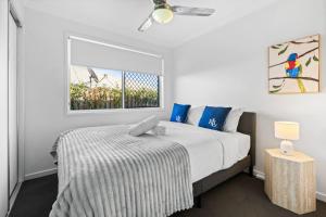 a white bedroom with a bed and a window at Cozy 2BR Home Quiet Bellbird Park Stay in Bellbird Park