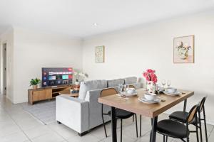 a living room with a table and a couch at Cozy 2BR Home Quiet Bellbird Park Stay in Bellbird Park