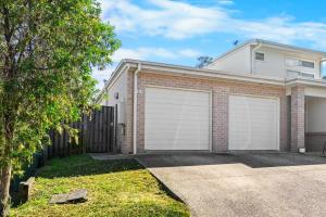 a brick house with two garage doors at Cozy 2BR Home Quiet Bellbird Park Stay in Bellbird Park