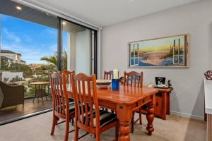 a dining room with a wooden table and chairs at Premium Coastal Abode with Parking Near Beach in Okura