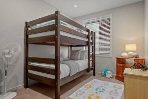 a bedroom with a bunk bed and a bathroom at Premium Coastal Abode with Parking Near Beach in Okura