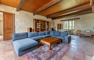a living room with a blue couch and a table at Le Clos Montaugé in Virsac