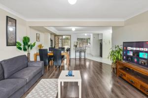 ein Wohnzimmer mit Sofa und Tisch in der Unterkunft 3BR Townhouse Stylish Living in Sunnybank Hills in Brisbane