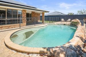 une piscine entourée d'un mur en pierre dans l'établissement Cozy Family Home near Shops and Transport with Pool, à Marsden