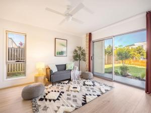 een woonkamer met een bank en een groot raam bij Elegant 5BR Family Home Modern Comfort in Rochedale in Rochedale