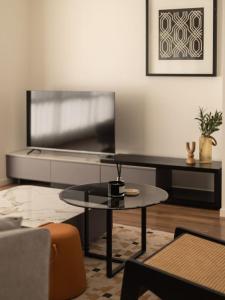 een woonkamer met een tafel en een tv bij Elegant 5BR Family Home Modern Comfort in Rochedale in Rochedale