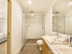 een badkamer met douche, wastafel en spiegel bij Elegant 5BR Family Home Modern Comfort in Rochedale in Rochedale +28 foto's